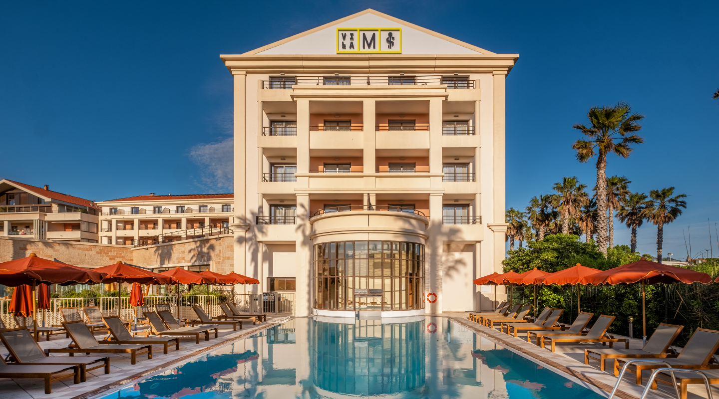 Luxury Villa M Marseille hotel with large outdoor pool, lounge chairs, and palm trees