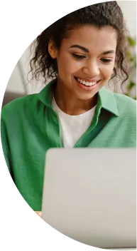 Fotografia de uma mulher sorrindo enquanto usa o computador