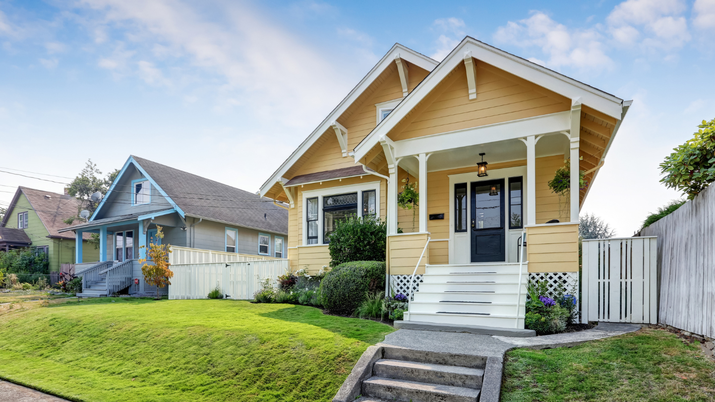 A yellow house with a white picket fence