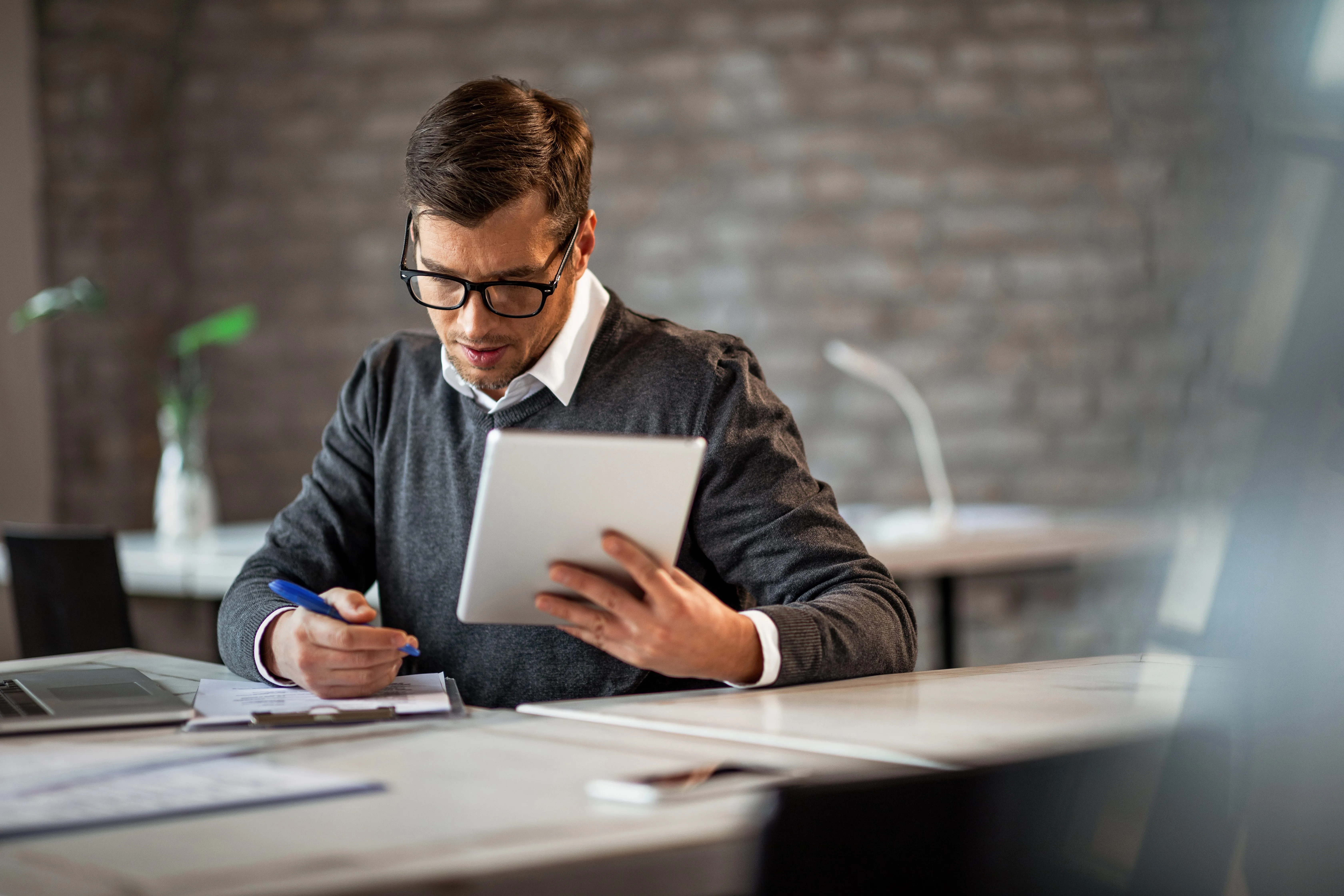 Businessman writing financial reports on a laptop.