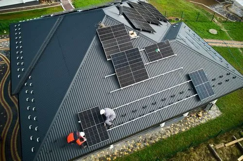 Männer installieren eine Solaranlage auf dem Dach
