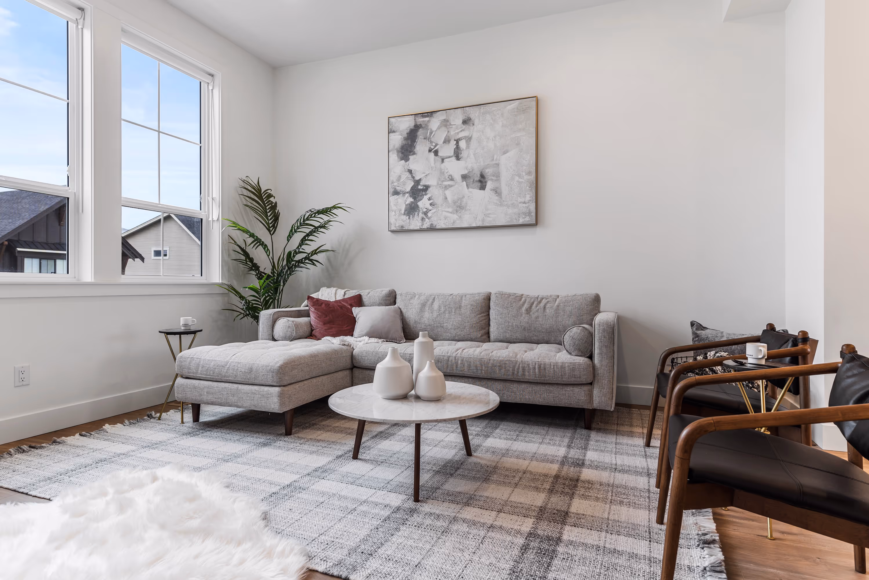 cedarbrook townhome living room with sectional couch, large plant, cozy rug and large windows