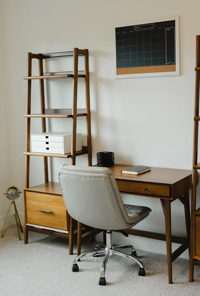 Modern home office with wooden desk, gray swivel chair, bookshelf, and wall calendar.