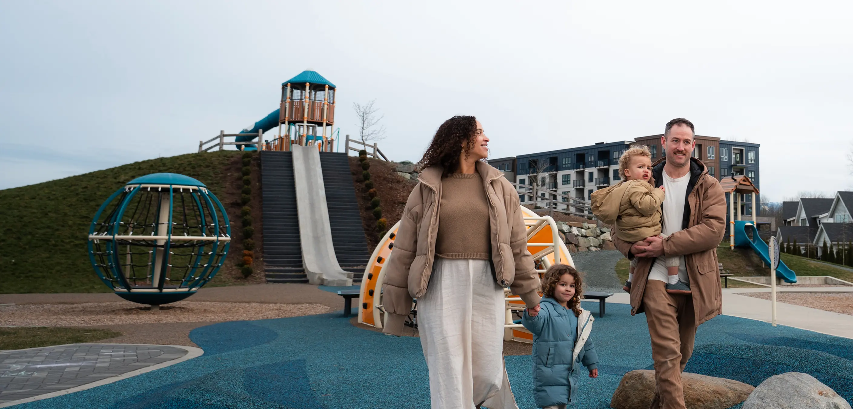 Smiling bearded man wearing a brown flat cap and black shirt against a dark brown background.