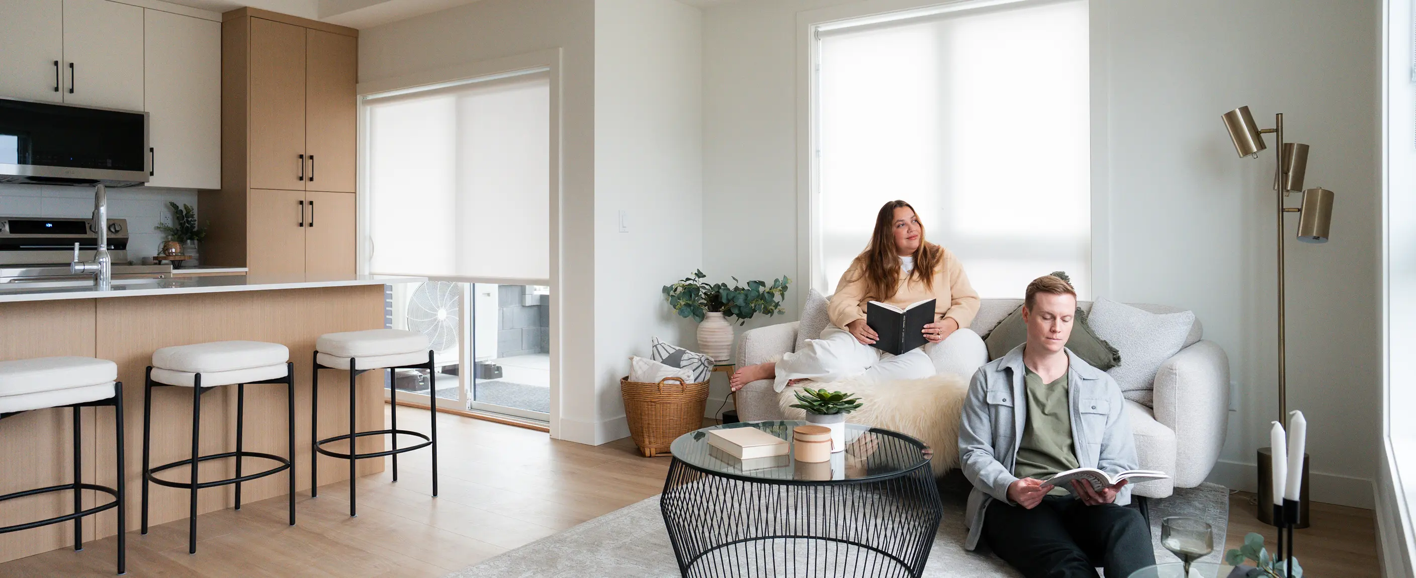 Smiling bearded man wearing a brown flat cap and black shirt against a dark brown background.