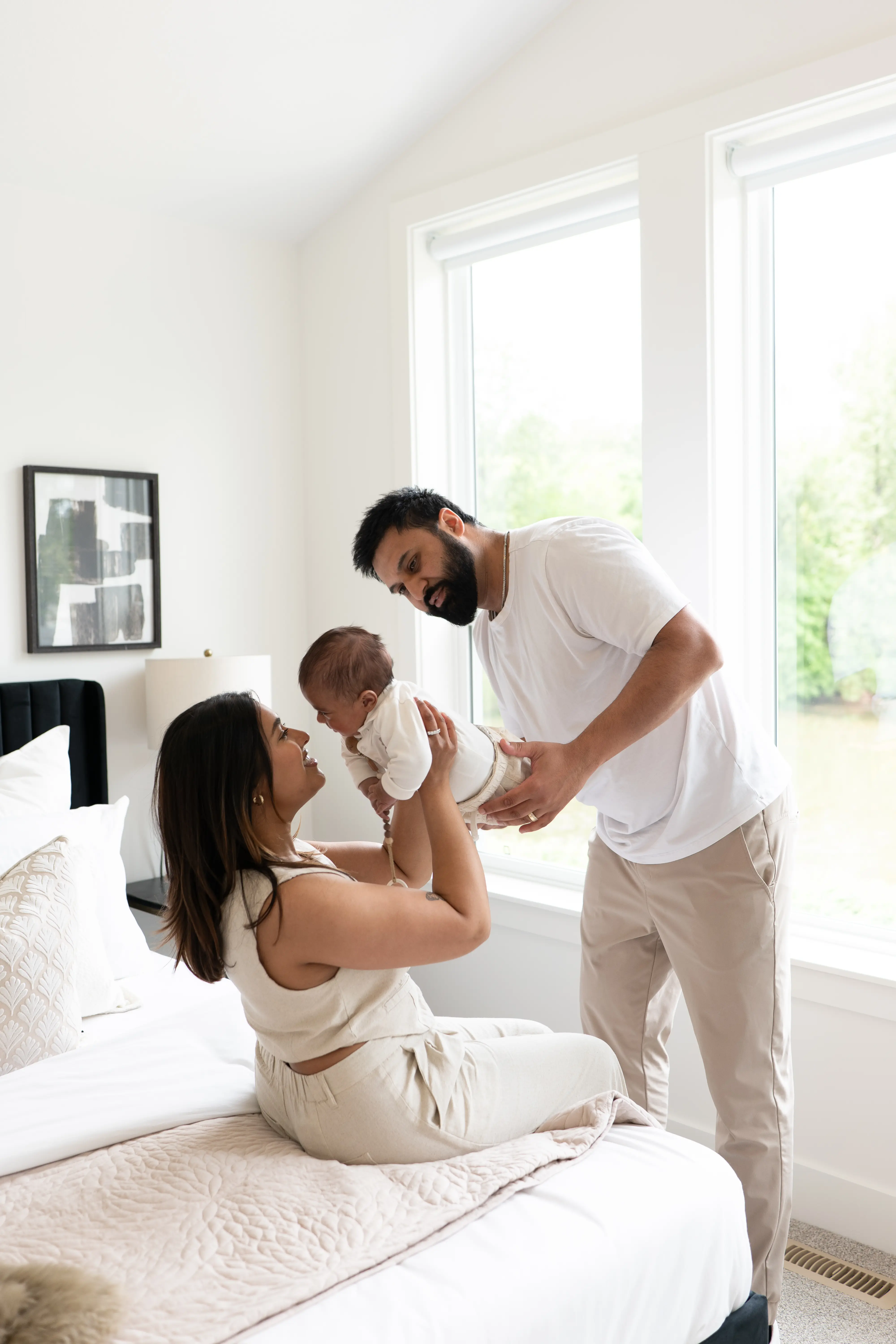 Smiling young couple holding a keyring with several keys in a bright room.