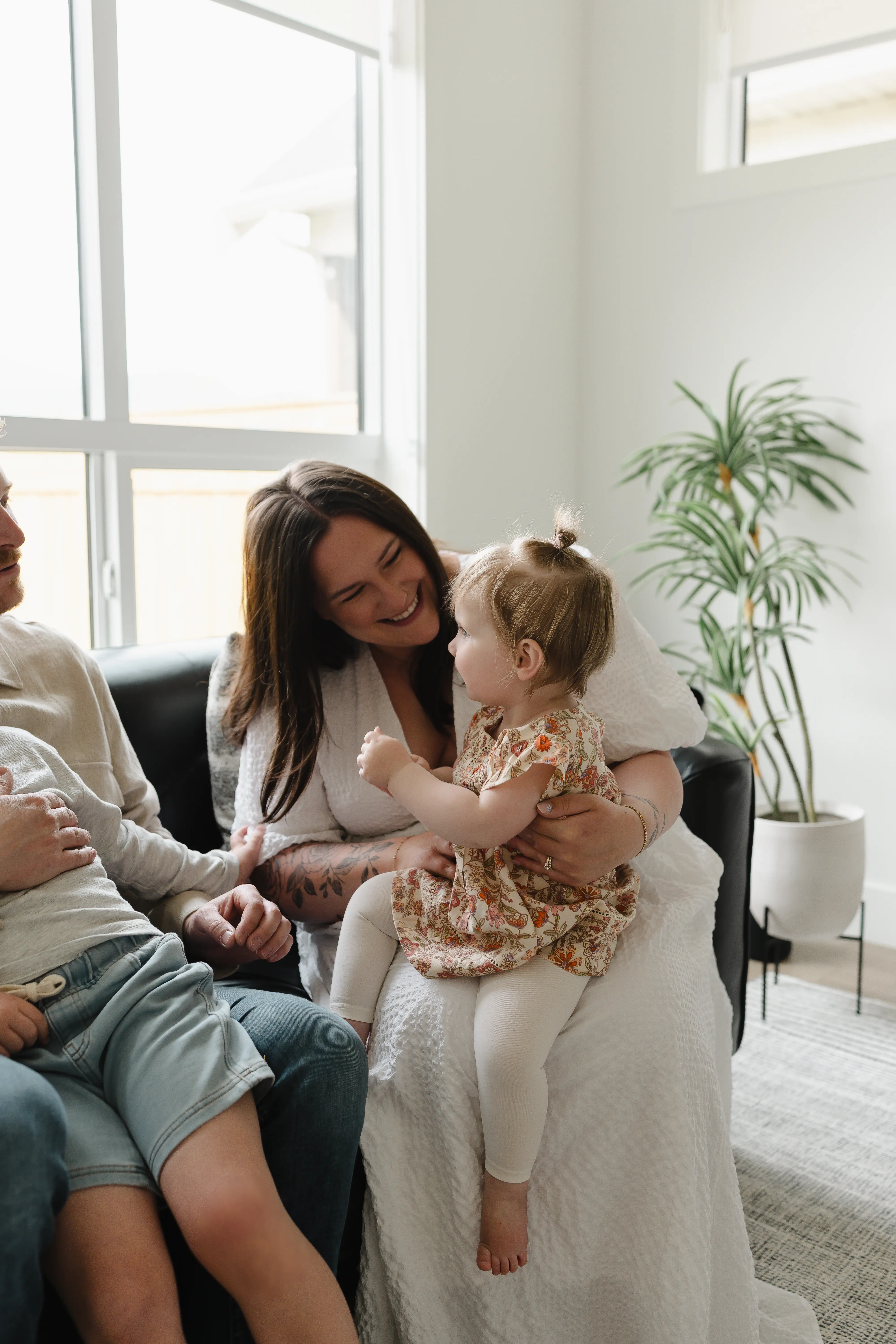 Smiling young couple holding a keyring with several keys in a bright room.