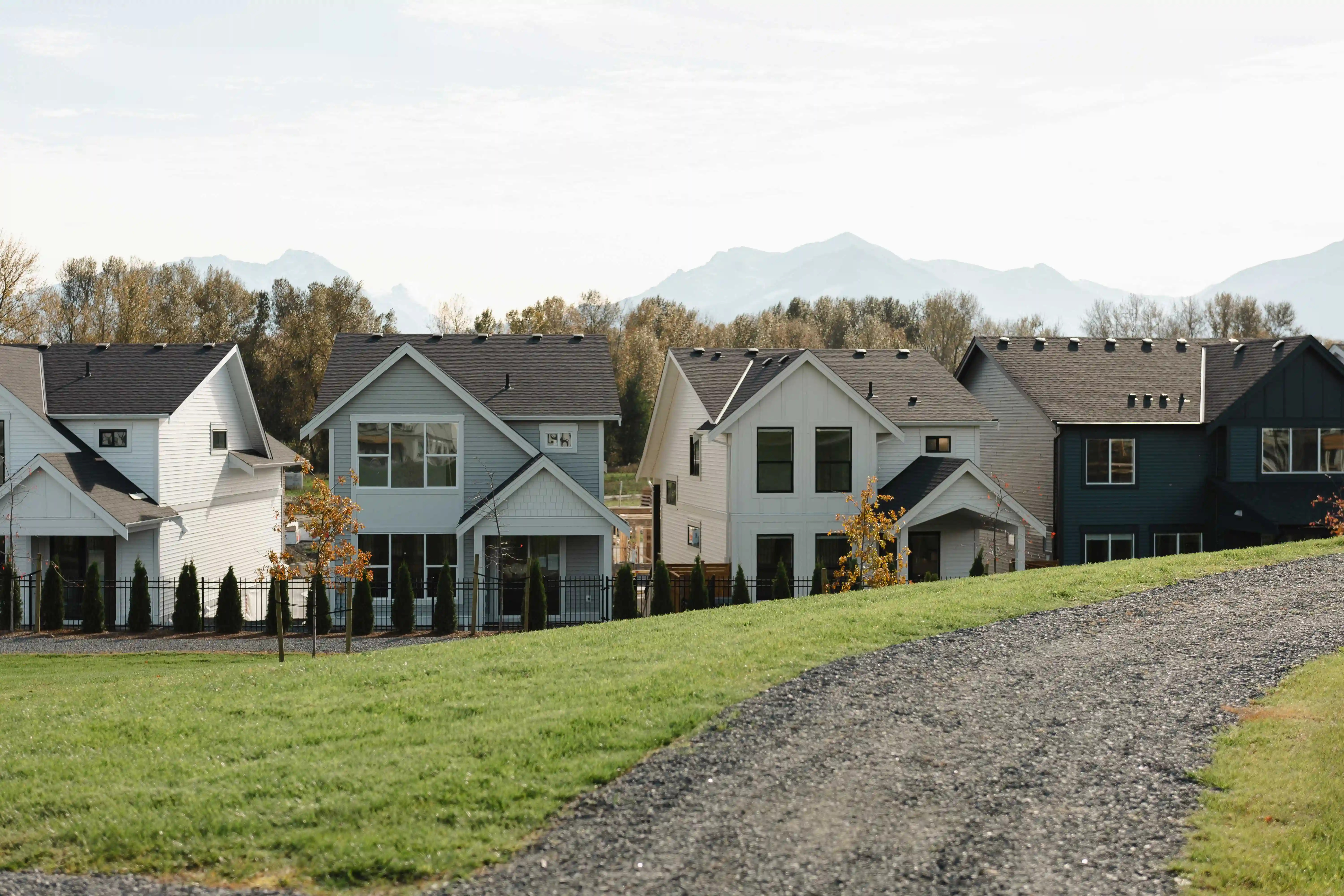 Smiling parents play and laugh with their young child on a white couch in a bright living room.