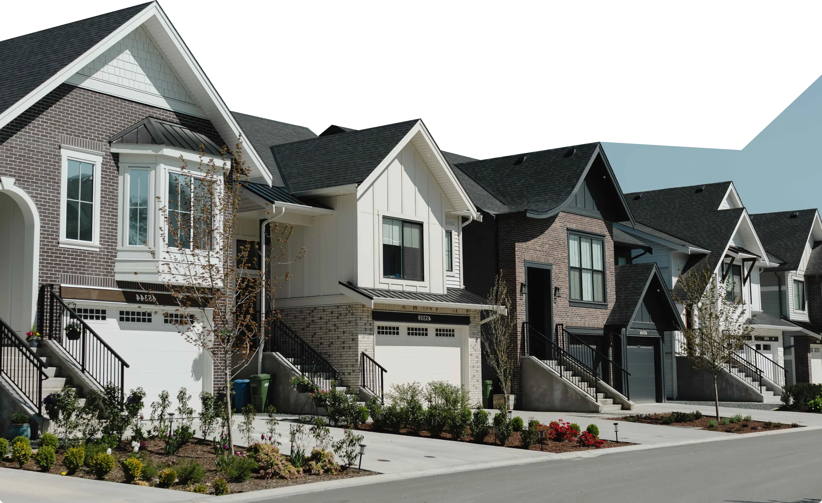 Row of modern suburban houses with brick and siding exteriors, each featuring garages and front steps with railings.