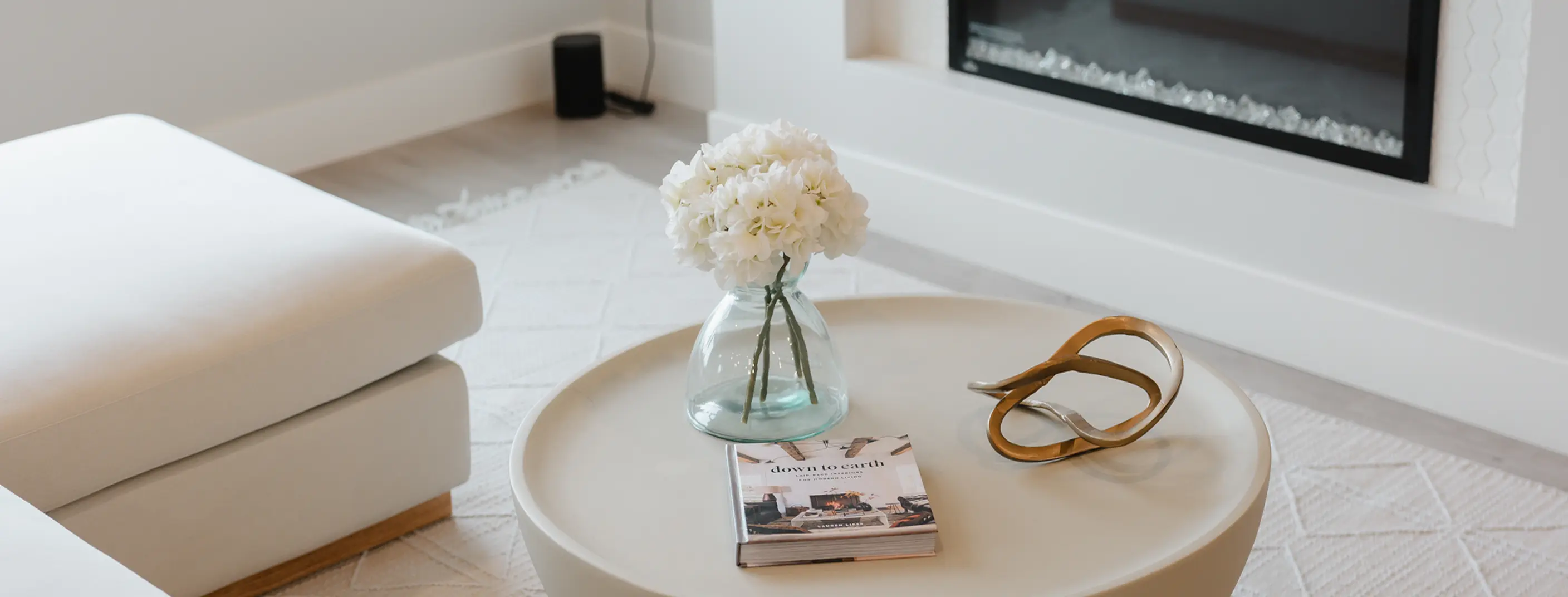 Smiling bearded man wearing a brown flat cap and black shirt against a dark brown background.