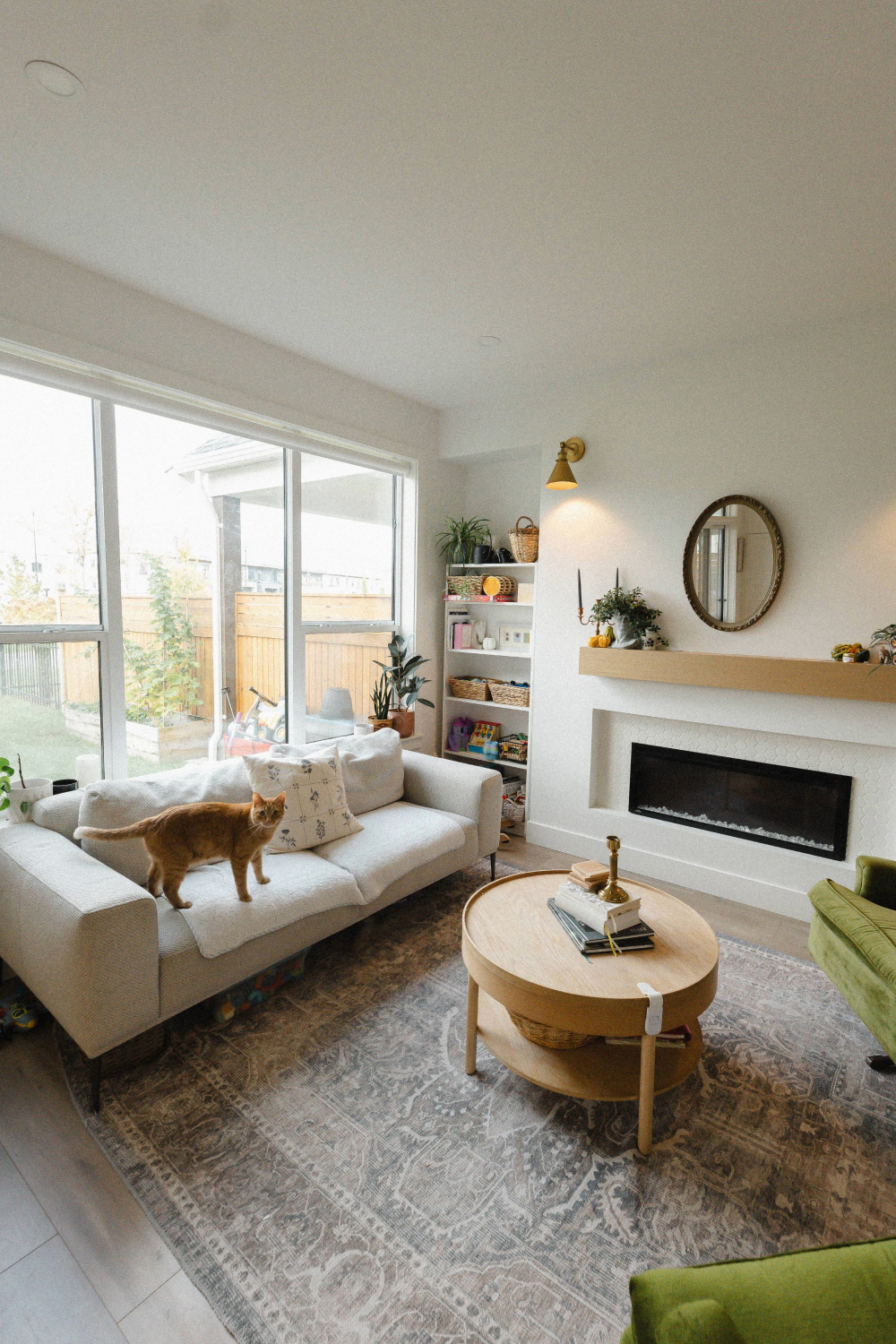 Modern two-story brick house with dark brown garage doors, large front window, and light gray front door accessed by stairs.