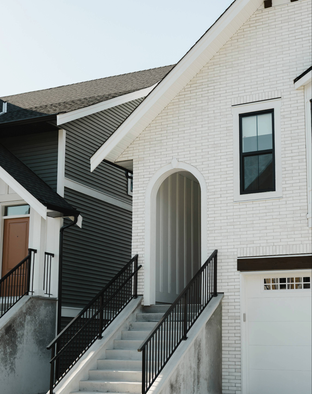 Woman unlocking a dark wooden front door with a key.