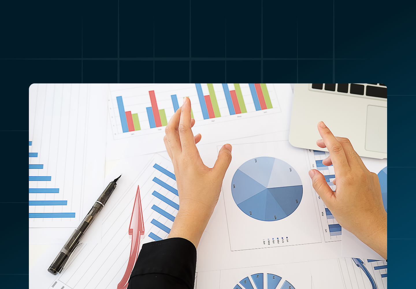 Looking down at hands on a desk with a laptop and papers with printed charts