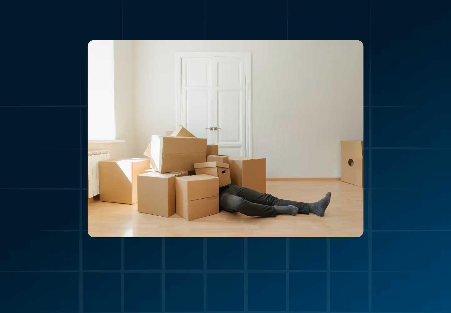 A person lying on the floor under a pile of boxes