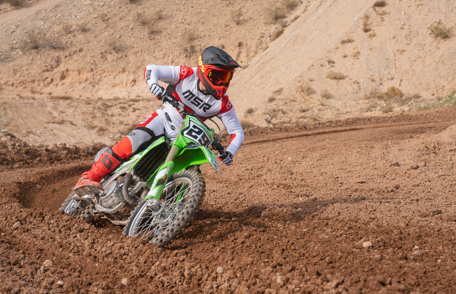 A rider wearing full MSR gear turning a corner. 