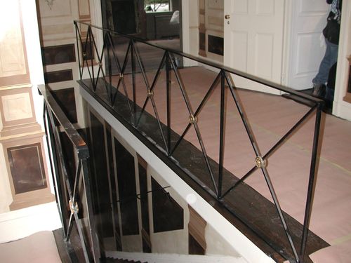 Metal railing for building interior with X shaped design.