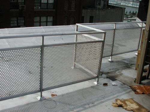 Metal railing/fence on perimeter of a building's roof.