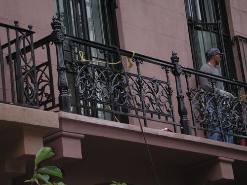 Black iron wrought security fences surrounding exterior balcony.