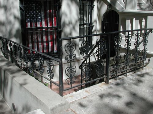 Short black security fence and gate in front of basement entrance.