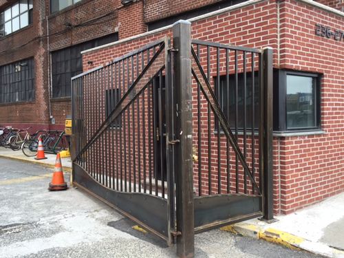 Metal security door with vertical bars and diagonal cut out.