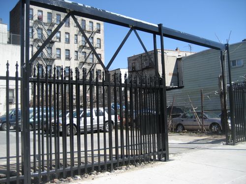 Street-level security bars with sliding gate and door for garage or parking lot.