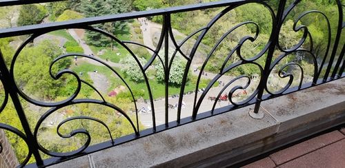 R145 Railing with ornate wrought iron balustrades with scrollwork and volutes, incorporating symmetrical arabesque patterns with sinuous curves