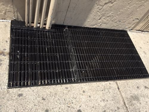 CD29 Rectangular, welded bar steel floor grate flush-mounted into a concrete sidewalk