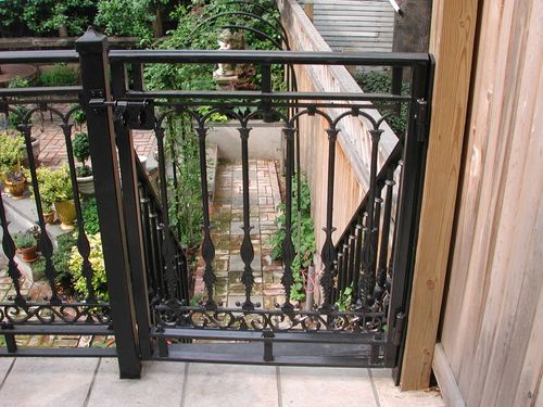 R178 Vertical pickets with alternating forged spear-point and scroll knuckle details, framed by square tubing and accented with a decorative cast iron scroll panel at the bottom, secured with surface-mounted hinges and a mechanical latch set.