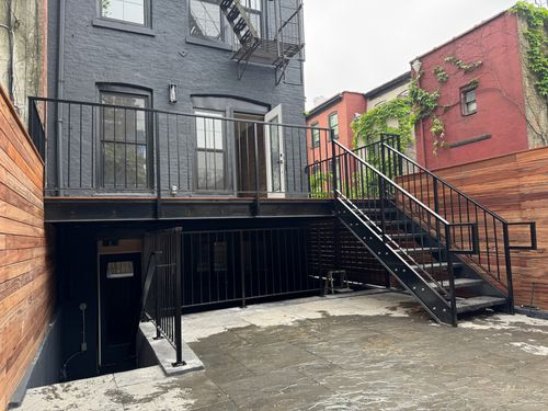 ST030 Exterior steel stair and platform system featuring diamond plate treads, a welded steel landing frame, and vertical picket guardrails