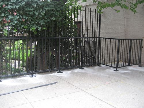 R195 modular steel security fence composed of vertical square pickets within welded rectangular frames, including a tall anti-climb section and a shorter perimeter barrie
