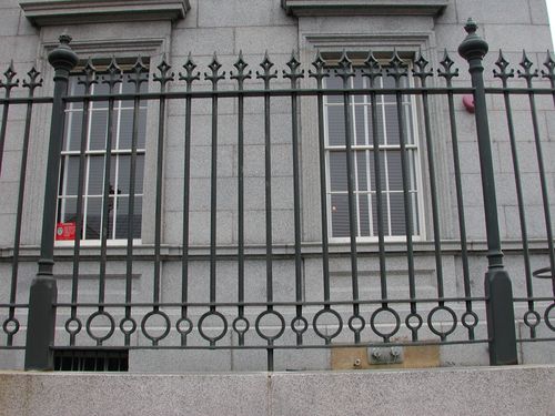 R200 Iron fence features vertical square pickets with spear-point finials, decorative circular motifs integrated into the mid-rail, and robust fluted posts with ball finials, all mounted atop a stone base