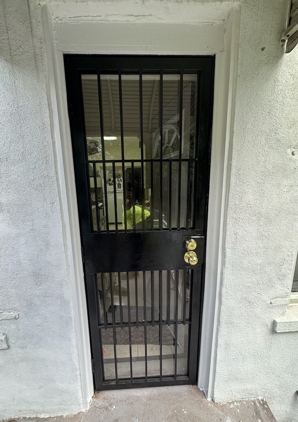 DG171 Security gate with horizontal center panel surrounded by closely spaced vertical bars with less densely spaced vertical pars on top and bottom to maximize light