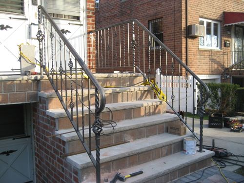 R205 Stair railing with twisted solid bar balusters and a pattern with straight and twisted pickets with decorative forged basket accents at varying heights