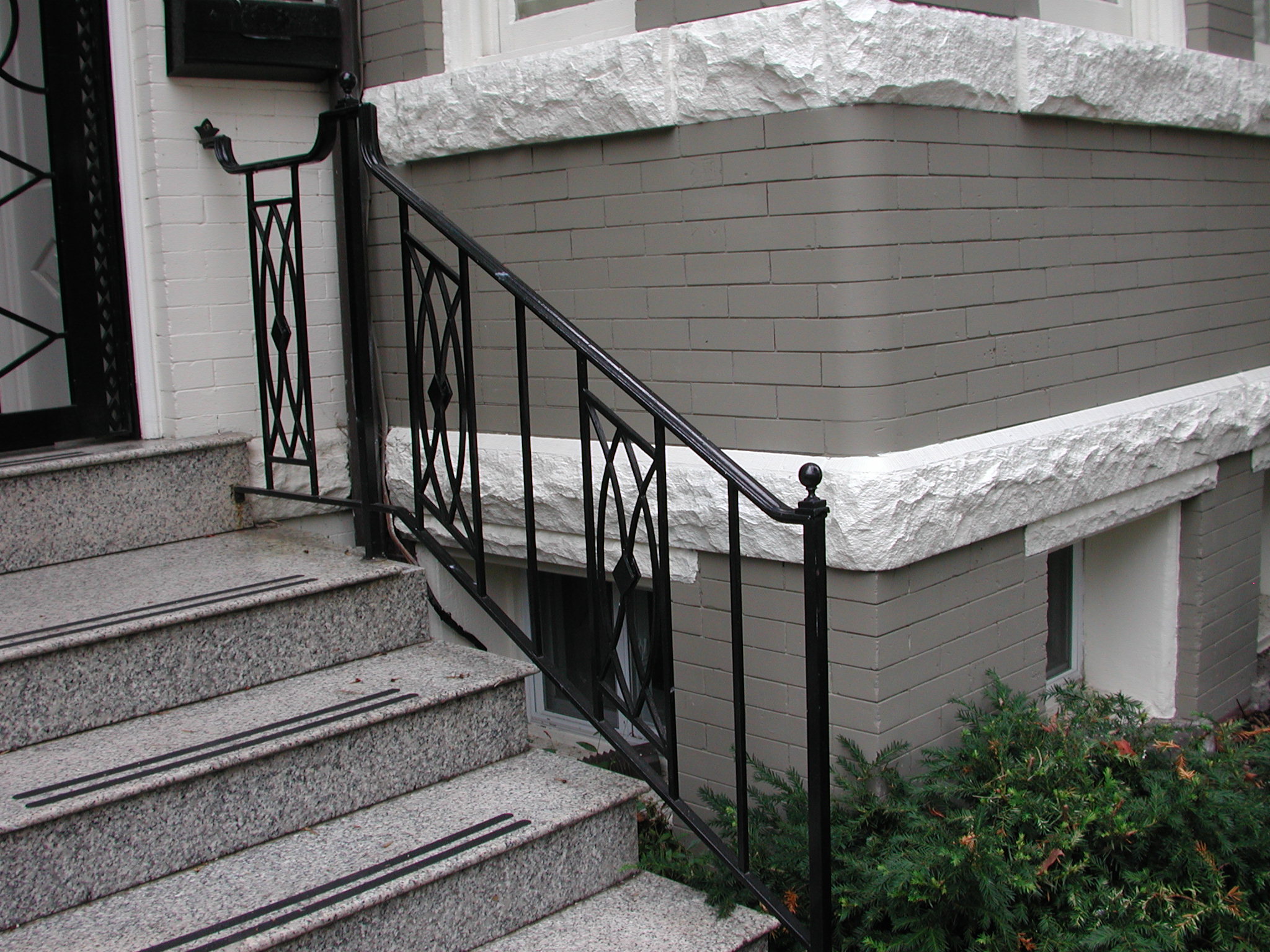 R214 Iron railing features vertical pickets with intersecting diagonal bars forming a diamond lattice pattern accented by a central lozenge detail in each panel.