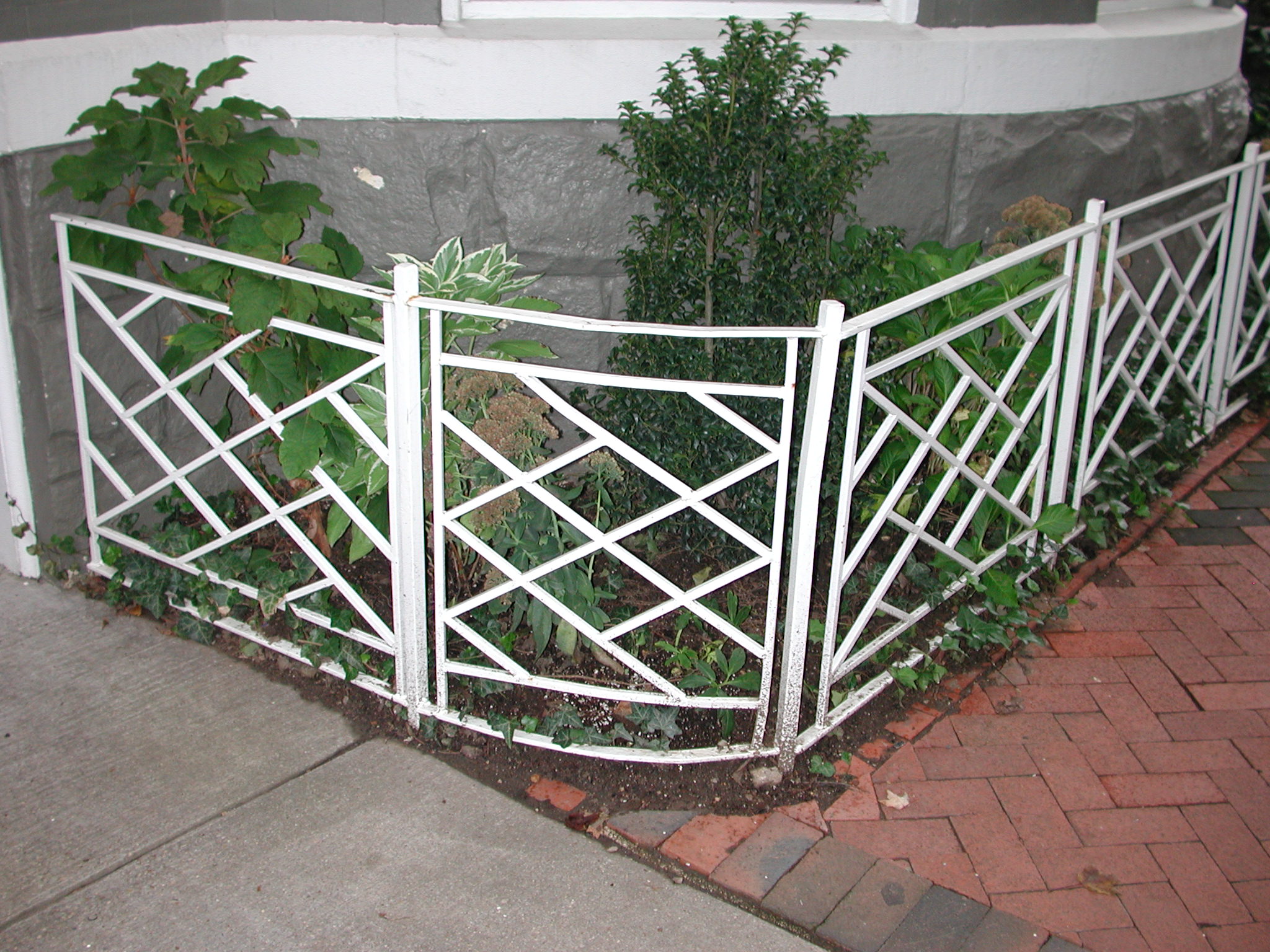 R216 Garden railing features a iron frame with intersecting diagonal bars forming a geometric lattice pattern between slender vertical posts