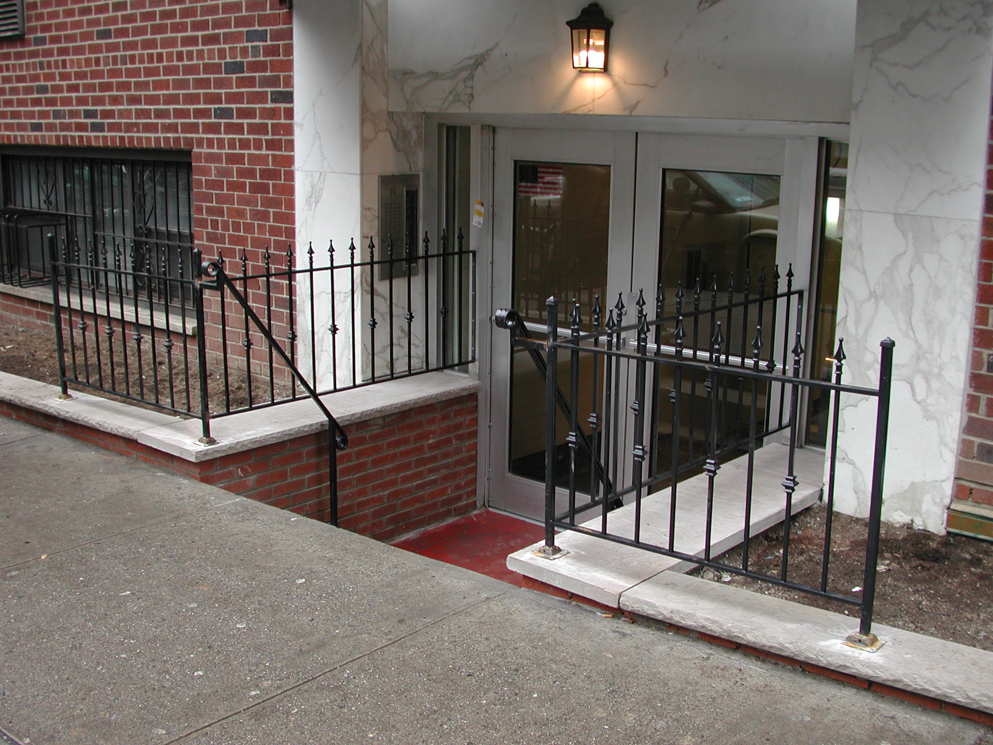 R217 iron railing features vertical pickets with decorative spear-point finials and intermediate collar accents, set between square posts with simple cap details