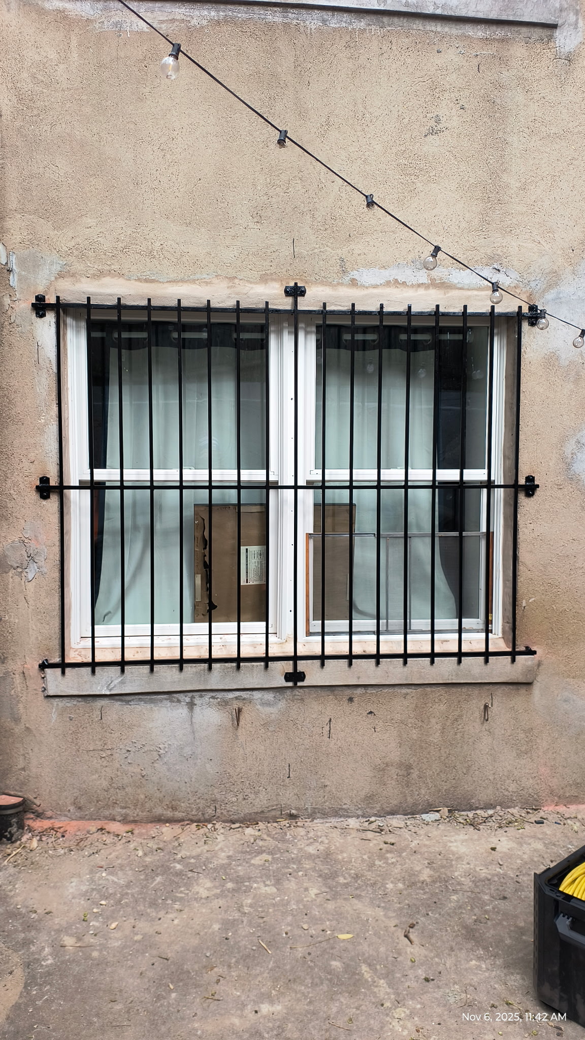 GU155 Double window grille with evenly spaced vertical bars, flat horizontal rails, and surface-mounted brackets