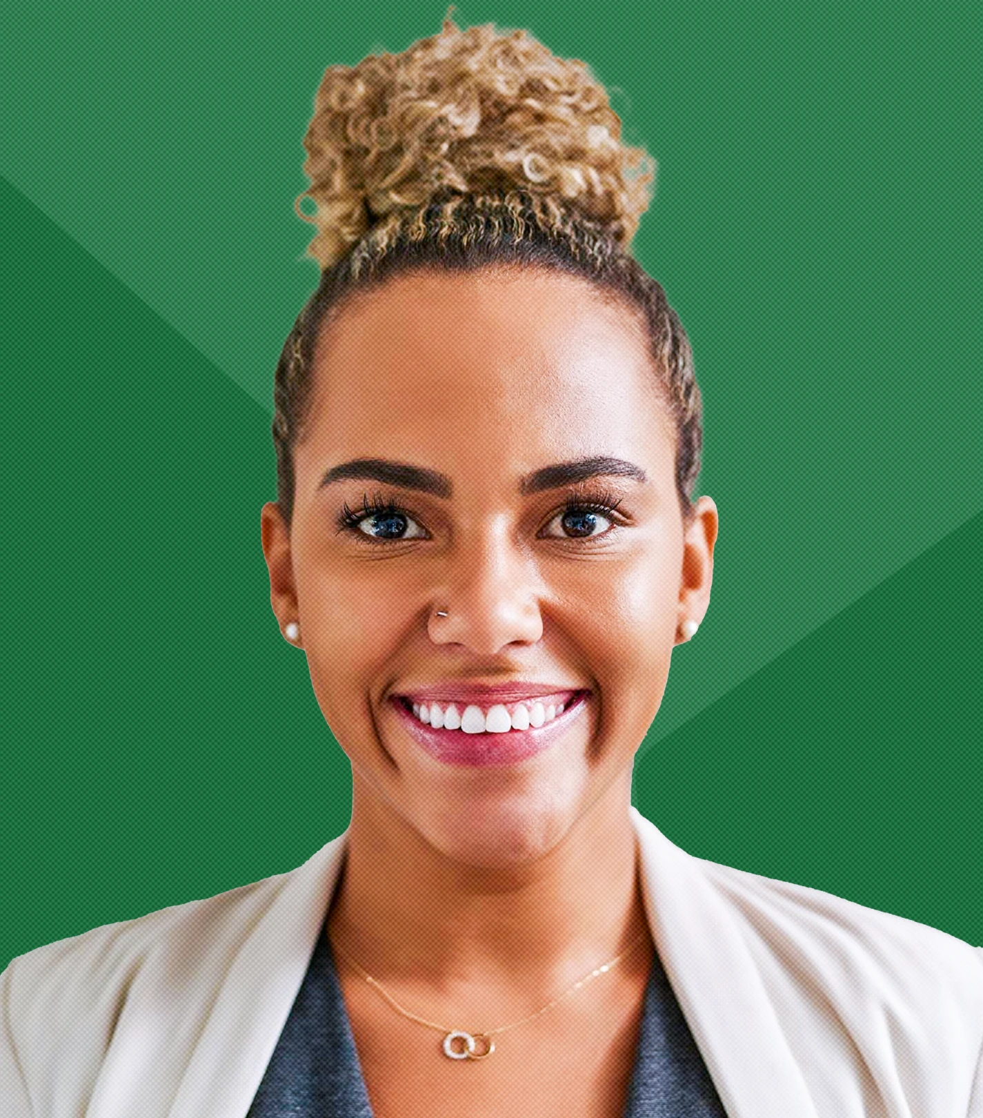 Smiling woman with curly blonde hair in a bun, wearing a beige blazer and gray top against a green background.