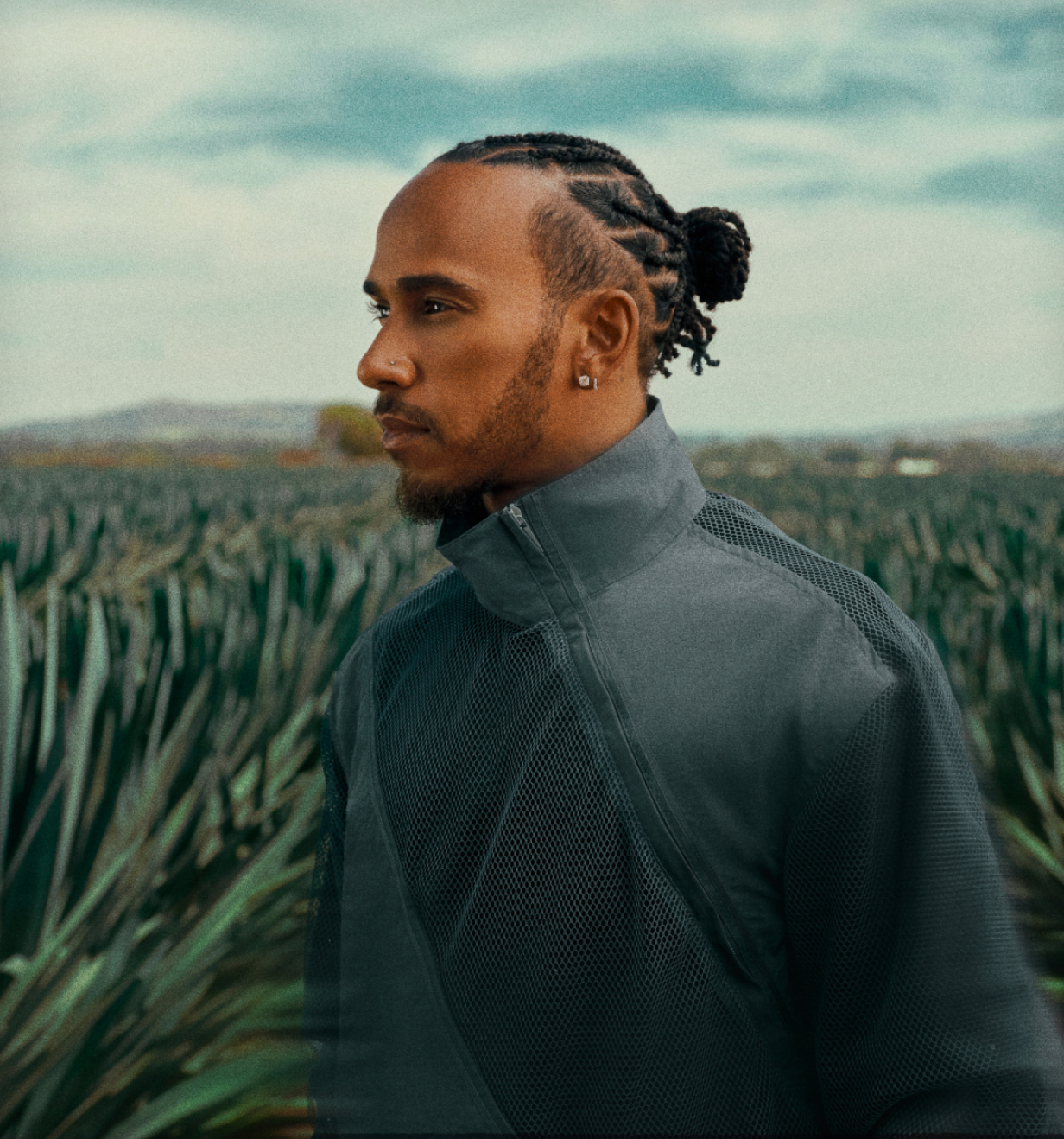 Man in a mesh jacket standing in an agave field for an ALMAVE brand campaign portrait.