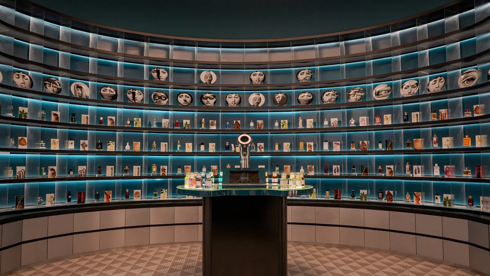 BEAUTI fragrance store interior with a curved, backlit wall of perfume bottles.