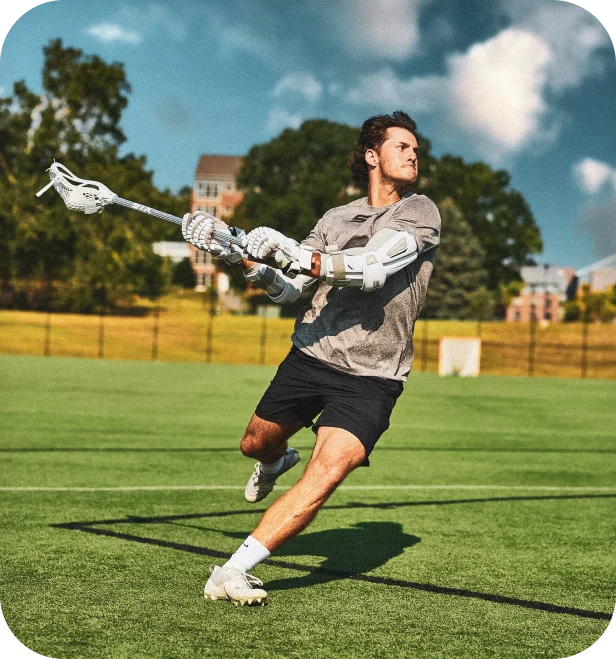 Lacrosse Unlimited lifestyle photo of a player winding up a shot on a grass field.