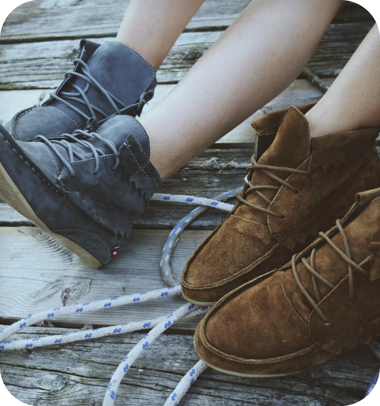 Oliberté lifestyle photo of two people wearing gray and brown suede leather boots on a wooden dock.
