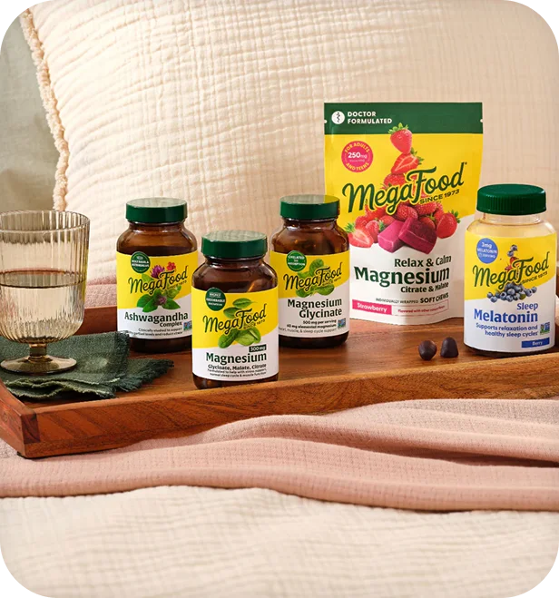 MegaFood lifestyle photo of magnesium, ashwagandha, and melatonin supplements on a bedside tray.