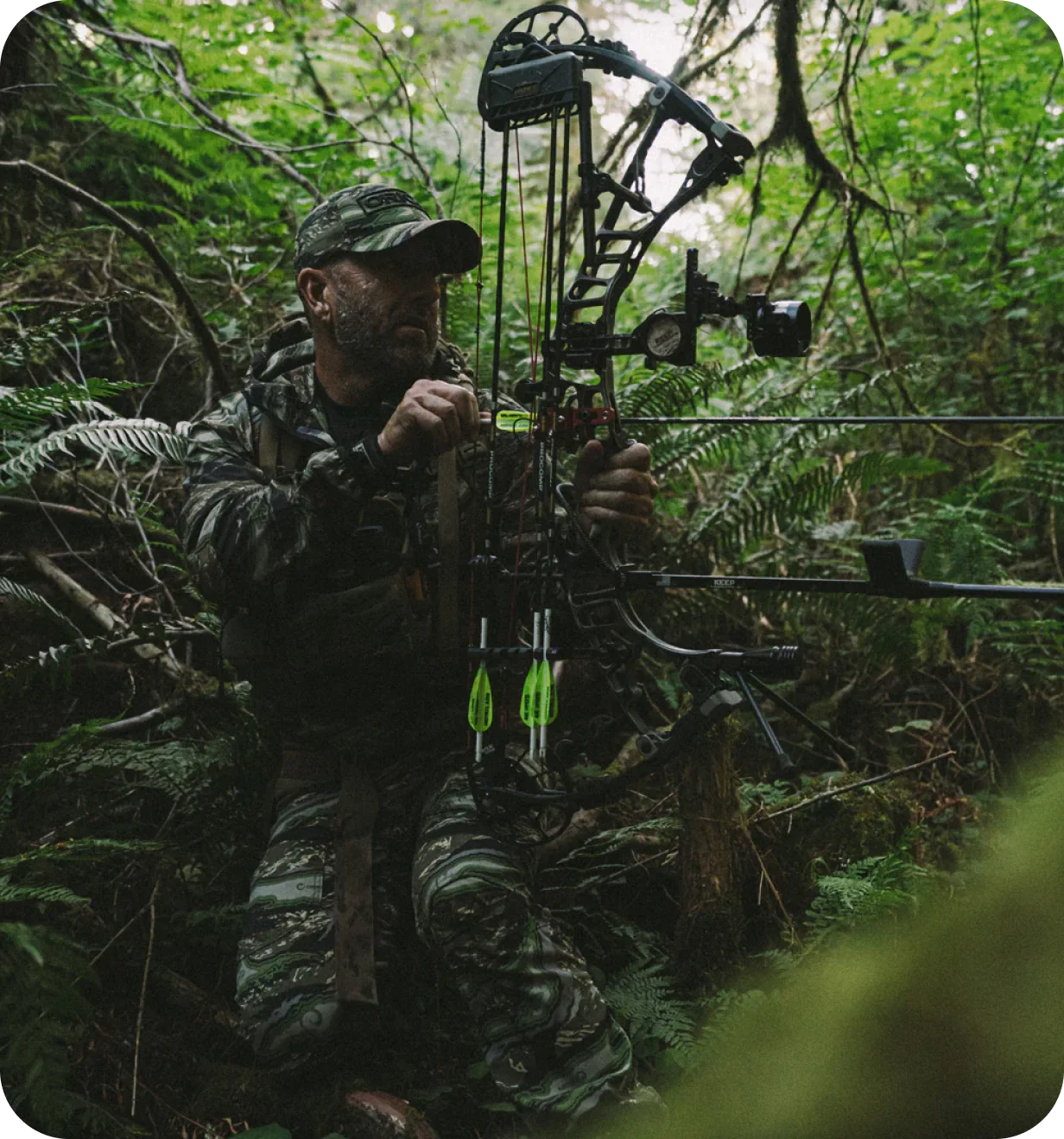 ORIGIN USA lifestyle photo of a bowhunter in camouflage adjusting a compound bow in the forest.