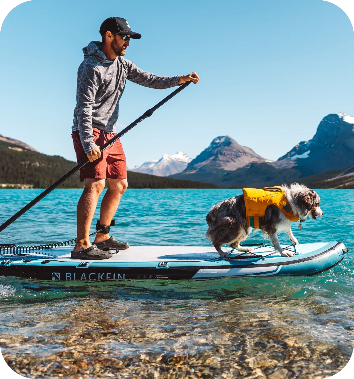iROCKER lifestyle photo of a paddler and dog on a Blackfin paddle board on a mountain lake.