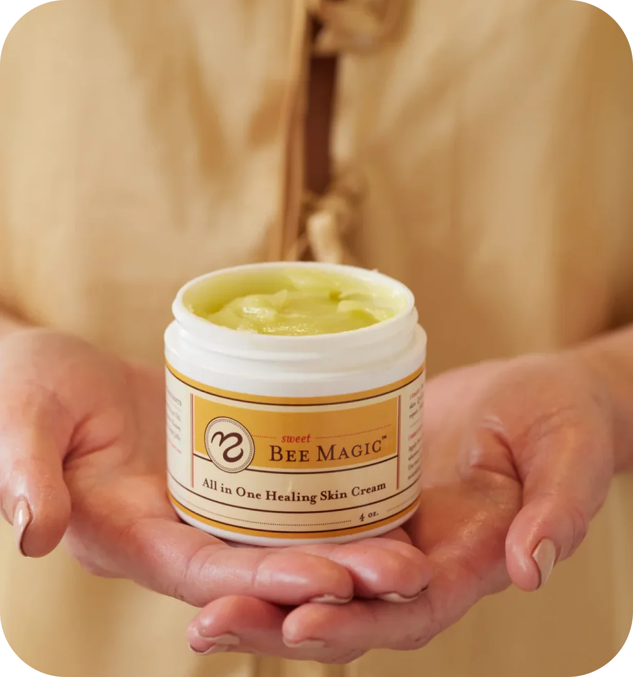 Sweet Bee lifestyle photo of hands holding an open jar of Bee Magic healing skin cream.