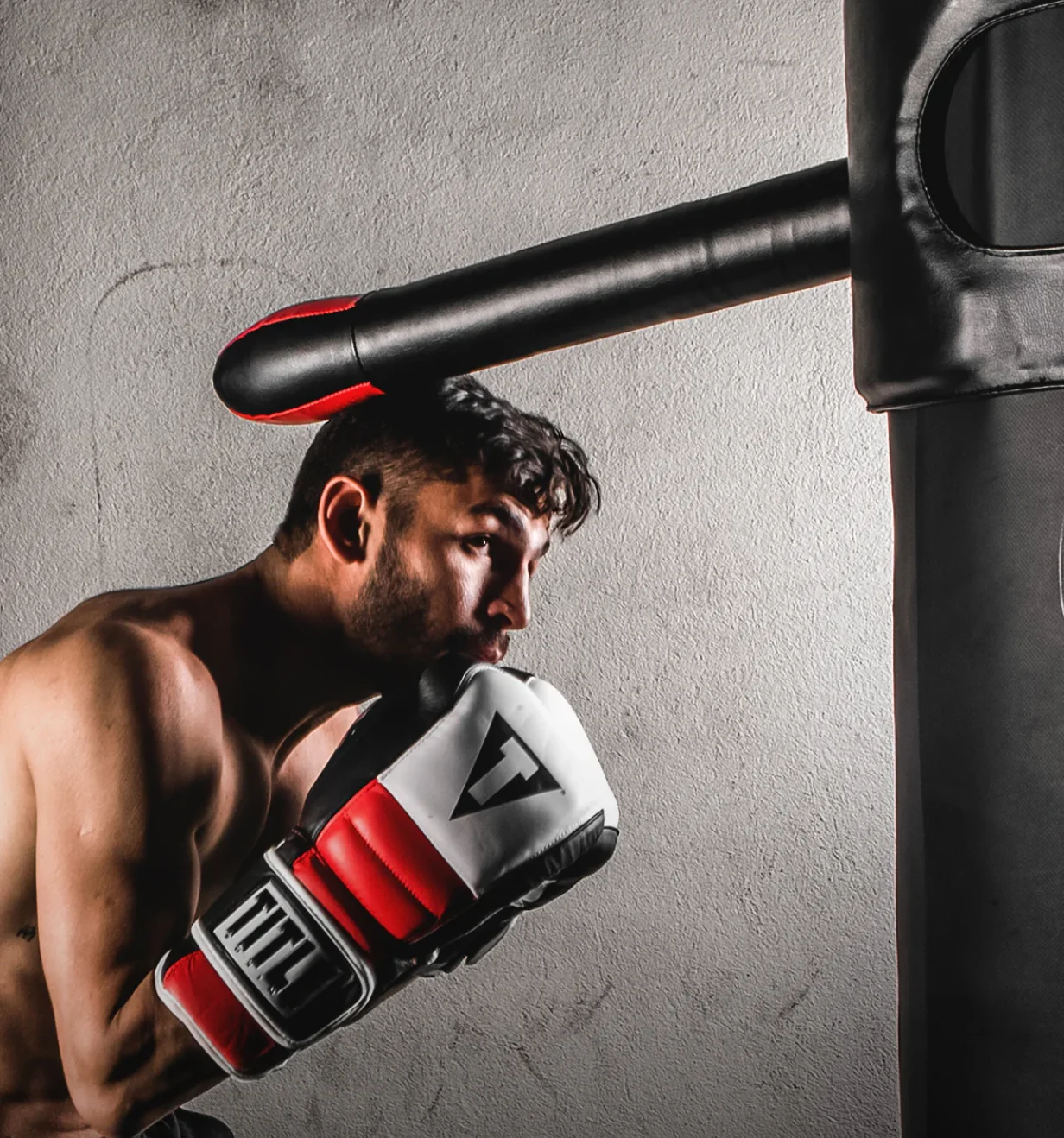 TITLE Boxing lifestyle photo of a boxer training on a heavy bag in TITLE gloves.