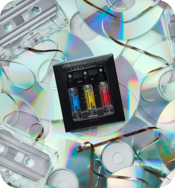 Snif lifestyle photo of a three-vial fragrance discovery set surrounded by CDs and cassette tapes.