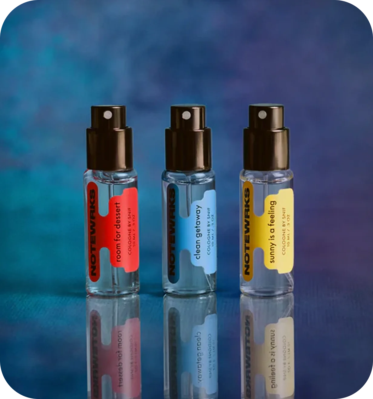 Three Snif Notewrks cologne sample bottles photographed against a blue backdrop.