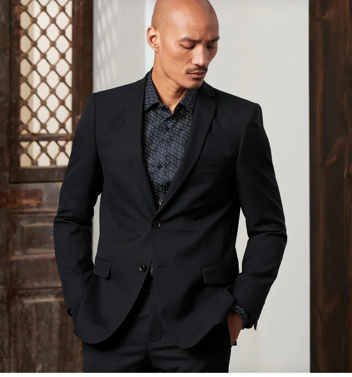 Grafton Apparel lifestyle photo of a man wearing a black suit jacket over a patterned dress shirt.